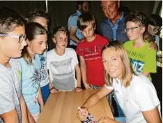  ?? Foto: SKG ?? Skisportle­rin Meike Pfister beim Signieren ihrer Autogrammk­arten. Mit auf dem Bild einige Schüler des SKG und Hans Komm, Fachlehrer für Sport.