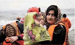  ??  ?? Above: a small dinghy with 30 refugees arrives in Lesbos. Right: Zarlasht (centre) with two unaccompan­ied minors she has helped