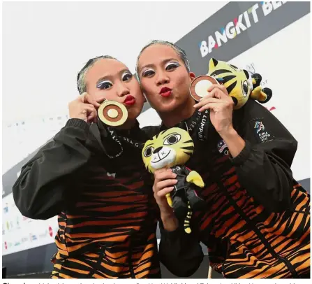  ??  ?? Glory days: Malaysia’s synchronis­ed swimmers Gan Hua Wei (left) and Zylane Lee Yhing Huey posing with their duet free routine gold medals at the 2017 KL SEA Games.