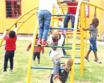  ??  ?? Children play on a jungle gym at a pre-school in Harare