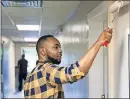  ?? OKLAHOMAN ARCHIVE] ?? Those who help others were most likely to thrive. Kyree Williams applies a new coat of paint to the walls in 2018 during the United Way Day of Caring at HeartLine Inc. in Oklahoma City. [CHRIS LANDSBERGE­R, THE