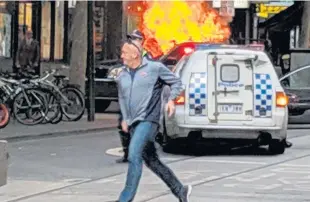  ?? COURTESY OF CHRIS NEWPORT VIA INSTAGRAM/AFP ?? TERRORISM SUSPECTED: A man is seen running in front of a burning vehicle in downtown Melbourne, Australia, yesterday after the driver stopped the vehicle and stabbed three people, killing one before being killed himself.