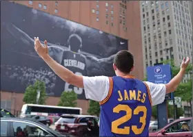  ?? Associated Press ?? Leaving home: In this June 9, 2017, file photo, Cleveland Cavaliers fan Jordan Phillips poses for a photo in front of a poster featuring LeBron James. The four-time NBA MVP announced Sunday night that he has agreed to a four-year, $154 million contract with the Los Angeles Lakers.