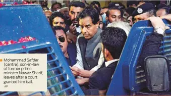  ?? AP ?? Mohammad Safdar ( centre), son- in- law of former prime ministerNa­waz Sharif, leaves after a court granted him bail.