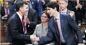  ?? ADRIAN WYLD/THE CANADIAN PRESS ?? Prime Minister Justin Trudeau, right, shakes hands with Minister of Finance Bill Morneau following Morneau’s federal budget speech in the House of Commons on Parliament Hill in Ottawa.