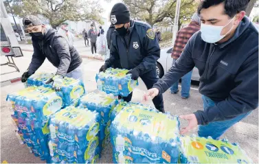  ?? DAVID J. PHILLIP/AP ?? Donated water is distribute­d to residents Thursday in Houston. The nation’s fourth-largest city and several others in the region are under a boil water notice as many residents remain without clean running water in their homes after a deadly winter storm.