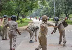  ?? — PTI ?? Police personnel charge during a clash with Banaras Hindu University students in Varanasi on Wednesday.