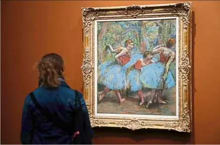  ?? — Photos: AFP ?? A visitor looking at a painting entitled Three Dancers In Blue Skirts And Red Corsages made around 1903 by Degas.
