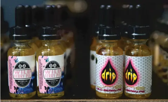  ?? | JUSTIN SULLIVAN/ GETTY IMAGES ?? Bottles of E- Juice that is used in E- Cigarettes or vaporizers is displayed at Digital Ciggz on January 28, 2015 in San Rafael, California. Some research suggests that sweeter flavors— think peanut butter cup or gummy bear – disproport­ionately attract young people.