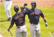  ?? Julio Cortez / Associated Press ?? J.D. Martinez of the Red Sox is greeted by Xander Bogaerts after the first of his three solo home runs.