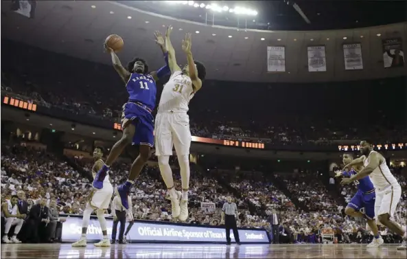  ??  ?? Kansas guard Josh Jackson (left) shoots over Texas forward Jarrett Allen (right) during the first half of an NCAA college basketball game Saturday in Austin, Texas. AP PHOTO