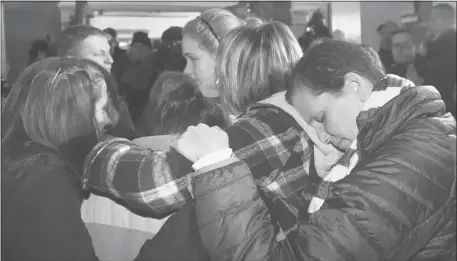  ?? Charles Krupa/the Associated Press ?? People were overcome with emotion as they gathered outside St. Rose of Lima Roman Catholic Church on Friday night. The church itself was filled.