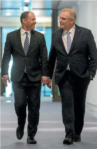  ?? ANDREW TAYLOR/AP ?? Australian Prime Minister Scott Morrison, right, walks to his first press conference with Deputy Leader of the Liberal Party Josh Frydenberg (file photo).