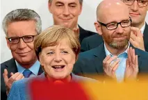  ?? PHOTO: REUTERS ?? Christian Democratic Union party leader and German chancellor Angela Merkel, front, reacts after winning the general election in Berlin.