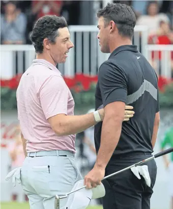  ??  ?? Rory McIlroy, left, is congratula­ted by Brooks Koepka after he won the Tour Championsh­ip and the FedEx Cup in August.