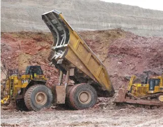  ??  ?? A GIANT Newmont Mining haul truck which is stuck in the mud gets a push from a convention­ally sized bulldozer at Newmont’s Carlin gold mine operation near Elko, Nevada, May 21, 2014.