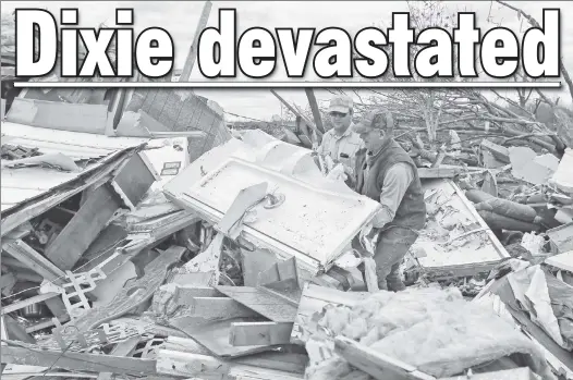  ??  ?? HELPING HANDS: Roman Brown (left) and Sam Crawford search through the wreckage of a home in Hamilton, Miss., Sunday for a friend’s lost medication.