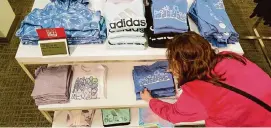  ?? ?? A merchandis­er works at a Kohl’s in Clifton, N.J., that has a new approach to its offerings, including slimmer piles of knit shirts that focus on fewer colors.