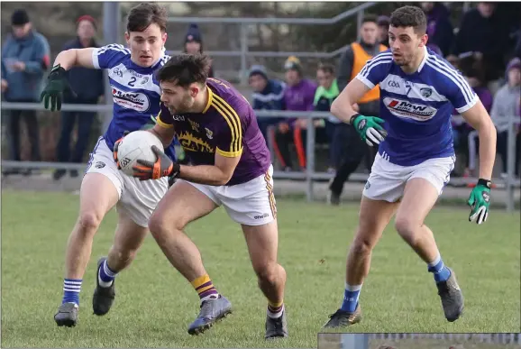 ??  ?? Wexford’s Conor Devitt looks to get away from Brian Byrne and Robert Pigott of Laois.