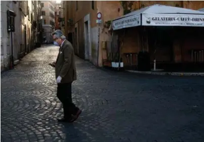  ??  ?? Een eenzame wandelaar op de Piazza Navona in Rome. Italië is zwaar getroffen door de coronapand­emie.