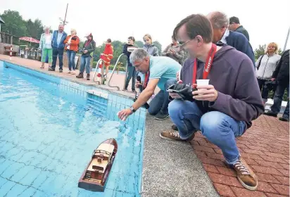  ?? RP-FOTOS: ACHIM BLAZY ?? Schiffstau­fe mit Sekt aus dem Plastikbec­her am Boot von Rainer Lietz (vorne).