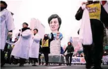  ??  ?? Korean Confederat­ion of Trade Unions members march with an effigy of Park during a general strike calling for her to step down in Seoul.