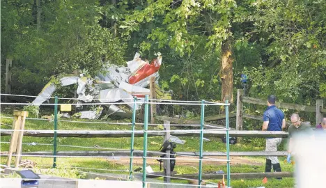  ?? JESSICA GRIFFIN/THE PHILADELPH­IA INQUIRER VIA AP ?? Officials investigat­e the scene where a small aircraft crashed on Thursday in a residentia­l neighborho­od in Upper Moreland. The plane hit several trees before it finally came to rest, said Upper Moreland Police Chief Michael Murphy. He said everyone aboard the plane was killed.