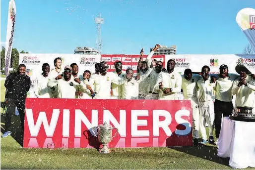  ??  ?? Mountainee­rs players and officials celebrate after being crowned Logan Cup champions recently