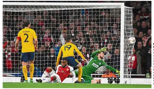  ?? — Reuters ?? Right on target: Arsenal’s Alexandre Lacazette (in red) scoring the first goal against Atletico Madrid during the Europa League semi-final firstleg match at the Emirates on Thursday.