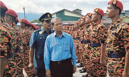  ?? [FOTO ZULIATY ZULKIFLI/BH] ?? Ku Abdul Rahman memeriksa perbarisan pelatih Pegawai Bomba Bantuan sambil diiringi Pegawai Bomba Zon 2 Sungai Petani, Mohd Mazukhi Shaffie, di Yan, semalam.