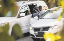  ?? Scott Strazzante / The Chronicle 2018 ?? A man pulls a bag through the broken window of a van parked on Lombard Street in January 2018. Burglars move quickly.