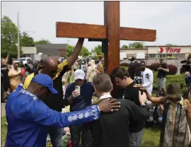  ?? JOSHUA BESSEX — THE ASSOCIATED PRESS ?? A group prays at the site of a memorial for the victims of the Buffalo supermarke­t shooting outside the Tops Friendly Market, on Saturday in Buffalo, N.Y.