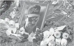  ?? JOHN BYRUM ?? A portrait of Dale Earnhardt sits in a memorial at his race shop on Feb. 19, 2001, a day after his death.