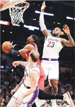  ??  ?? Toronto Raptors' Rondae Hollis-Jefferson, center, drives to the basket as Los Angeles Lakers' LeBron James (23) defends. (AP)