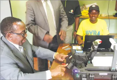  ??  ?? Economic Planning and Investment Promotion Minister Simon Khaya Moyo being assisted by Zimbabwe Electoral Commission registrati­on officer Innocent Biya (right) to register as a voter in Mbare, Harare, yesterday. — (Picture by Justin Mutenda)