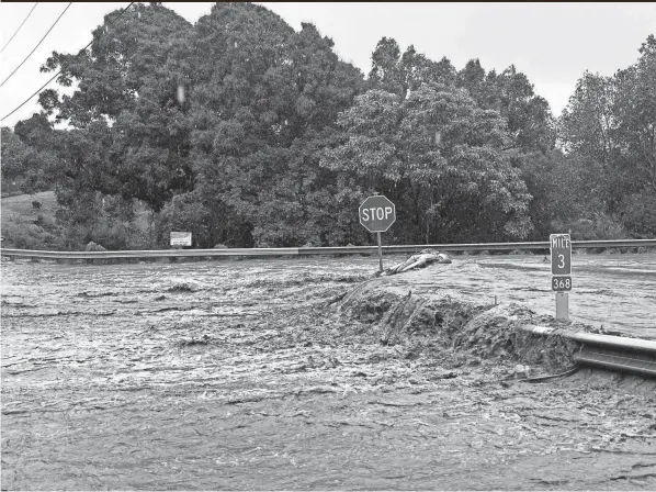  ?? KEHAULANI CERIZO/THE MAUI NEWS VIA AP, FILE ?? Floodwater sweeps over Maui’s Hana Highway in Haiku, Hawaii, after heavy rains caused a dam to overflow in March.