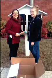  ??  ?? Espi Pirir (left) and Madison Denny, of the LaFayette High School HOSA Club, donate to the Little Free Pantry at 201 South Duke St. in LaFayette. (Contribute­d photo)