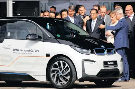  ??  ?? Harald Krueger, the chief executive of BMW, German Chancellor Angela Merkel and Chinese Prime Minister Li Keqiang attend a presentati­on for autonomous driving next to a BMW car at Tempelhof airport in Berlin, Germany, yesterday.