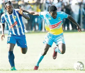  ??  ?? Mount Pleasant’s Kemar Beckford (left) stays close to Waterhouse’s Kenroy Howell in their Red Stripe Premier League encounter at Drax Hall on Sunday, September 23, 2018.