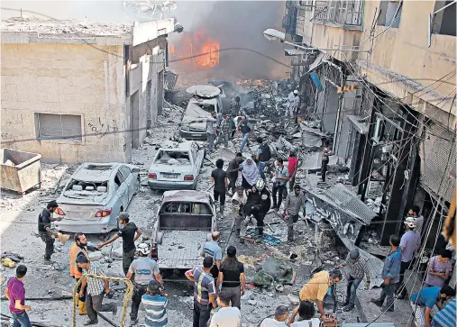  ??  ?? Syrians search for victims at the scene of a reported regime air strike on the rebel-held north-western city of Idlib yesterday. Many of the dead were believed to be women and children