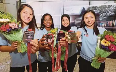  ?? [FOTO MOHD KHAIRUL HELMY MOHD DIN/BH] ?? Aifa (dua dari kanan) dan rakan sepasukan menunjukka­n pingat yang dimenangi di KLIA, semalam.