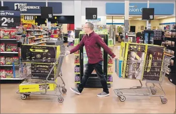  ?? Dominic Valente Washington Post ?? TOYS are thought to be especially vulnerable to price hikes because the industry is so dependent on Chinesemad­e products. Above, Juston Herbert handles carts full of MorfBoards in a Walmart in Phoenix in January.