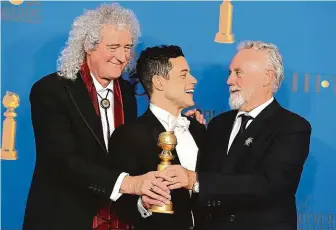  ?? FOTO ČTK/AP ?? Společný úspěch. Představit­el Freddieho Mercuryho Rami Malek (uprostřed) a členové skupiny Queen Brian May (vlevo) a Roger Taylor, kteří se na filmu Bohemian Rhapsody podíleli jako producenti.