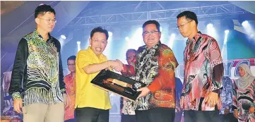  ??  ?? Dr Sim (second left) accepts a memento from Sempurai, witnessed by SRDC deputy chairman Robert Lau Hui Yew (left) and Sibu Jaya Festival 2017 organising chairman Councillor Kong Chek King.