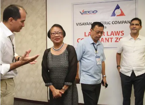  ?? JOY TORREJOS ?? VECO’s chief operating officer Sebastian Lacson (left) talks with DOLE Secretary Rosalinda Baldoz during the unveiling of the labor laws complaint zone marker at the entrance gate of the power utility’s office in Banilad. Also in photo are DOLE7...