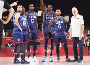  ?? Gregory Shamus / Getty Images ?? From left, Zach Lavine, Jrue Holiday, Bam Adebayo, Kevin Durant, Damian Lillard and coach Gregg Popovich of the United States look on during their game against France.