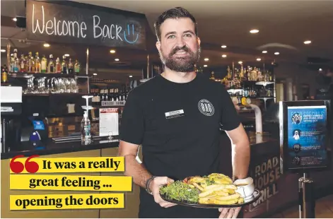  ?? Picture: MATT TAYLOR ?? SERVICE WITH A SMILE: Venue manager Anthony Robertson serves a meal at Tom’s Tavern as COVID-19 restrictio­ns begin to lift.
