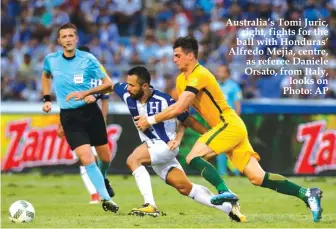  ??  ?? Australia’s Tomi Juric, right, fights for the ball with Honduras’ Alfredo Mejia, centre, as referee Daniele Orsato, from Italy, looks on Photo: AP