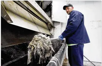  ?? CHRIS STEWART / STAFF ?? Josh Feltz, a wastewater plant operator, shows a glob of wipes captured by the screening system at Montgomery County’s Eastern Regional Wastewater Treatment Plant. The county spends at least $200,000 a year unclogging, repairing equipment and disposing...