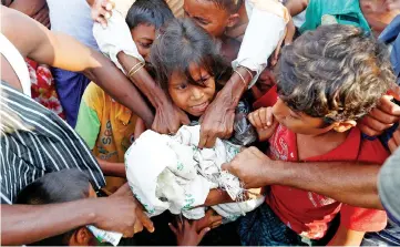  ??  ?? Rohingya refugees jostle to receive food distribute­d by local organisati­ons after crossing the Bangladesh-Myanmar border by boat through the Bay of Bengal in Teknaf, Bangladesh. — Reuters photo